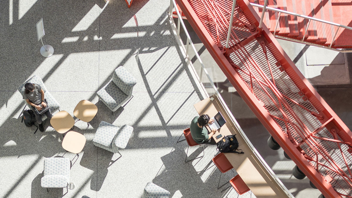 overhead shot of students working and studying at tables in the student hall for exploration and development (SHED)