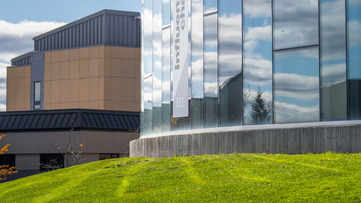 University Services Center building glass facade and lawn with clouds autumn global village