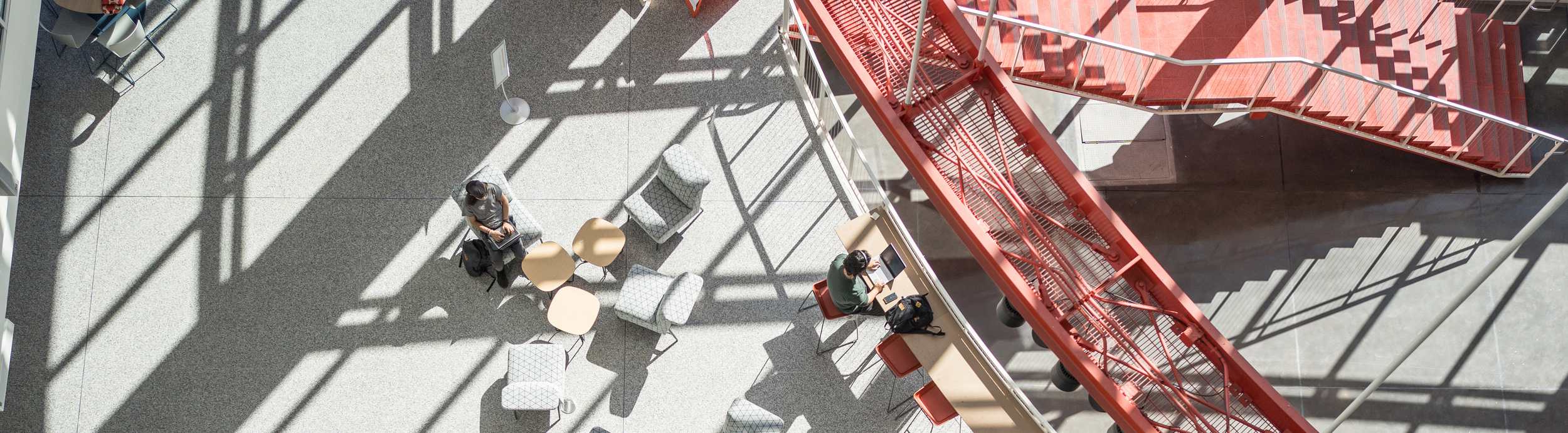 overhead shot of students working and studying at tables in the student hall for exploration and development (SHED)