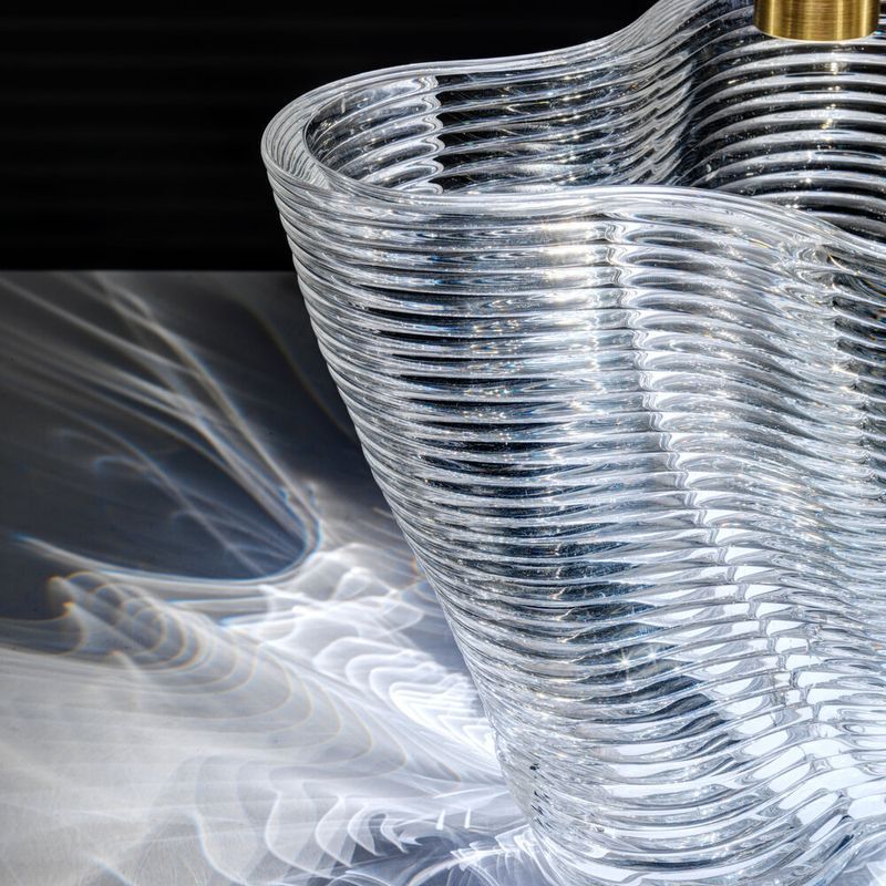 a close up of a 3D printed clear glass with a layered, undulating surface.