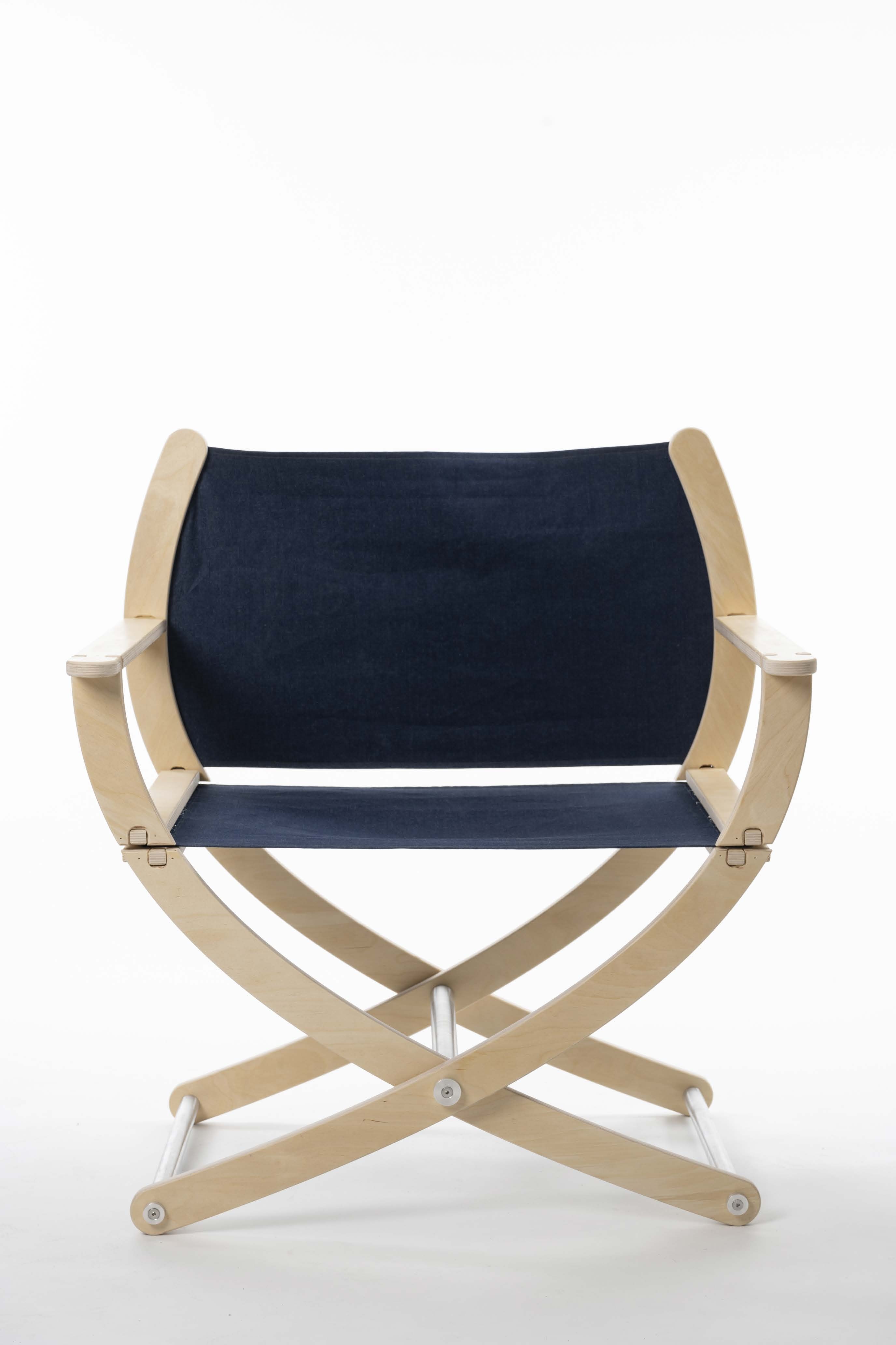 a view of a folding chair design with natural wood arms and legs and a black fabric seat and back.