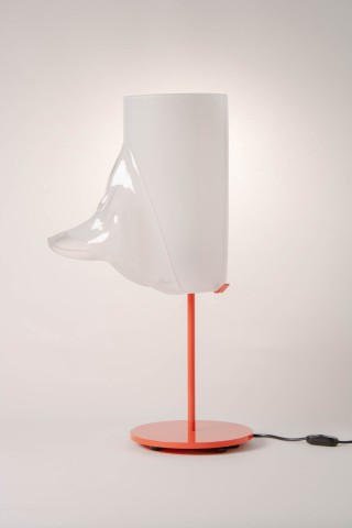 a lamp with a red metal base and glass shade against a grey background.