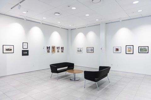interior image of University Gallery with art on the walls and furniture arranged in the center.